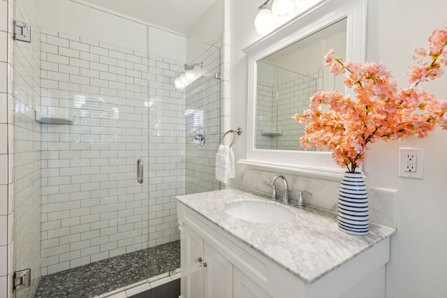 bathroom featuring vanity and a shower with door