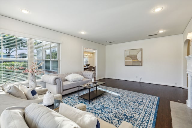 living room with wood-type flooring and a notable chandelier