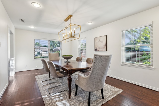 dining room with dark hardwood / wood-style floors and a notable chandelier