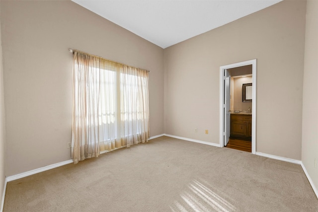 unfurnished bedroom with ensuite bathroom and carpet floors