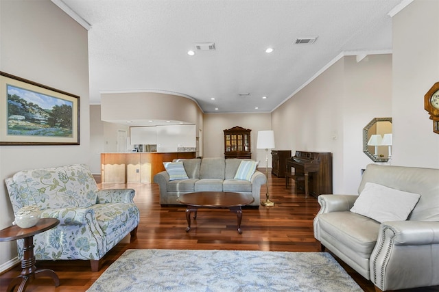 living room featuring hardwood / wood-style flooring, ornamental molding, and a textured ceiling