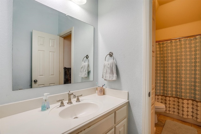 bathroom featuring vanity, tile patterned flooring, and toilet