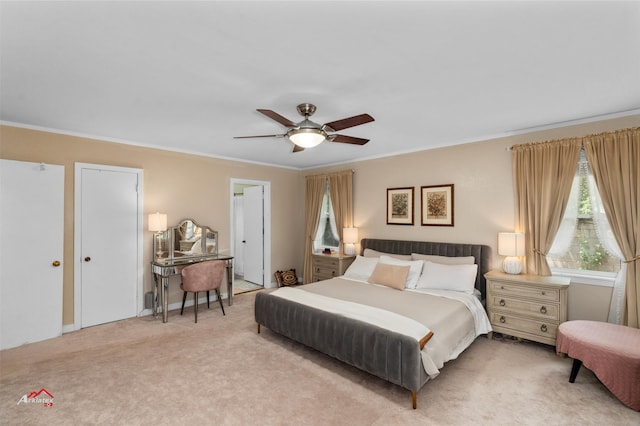 carpeted bedroom with ornamental molding and ceiling fan