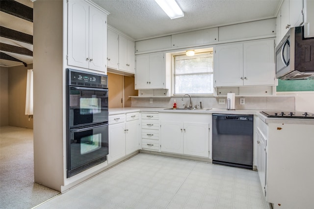 kitchen featuring light carpet, white cabinets, a textured ceiling, black appliances, and sink