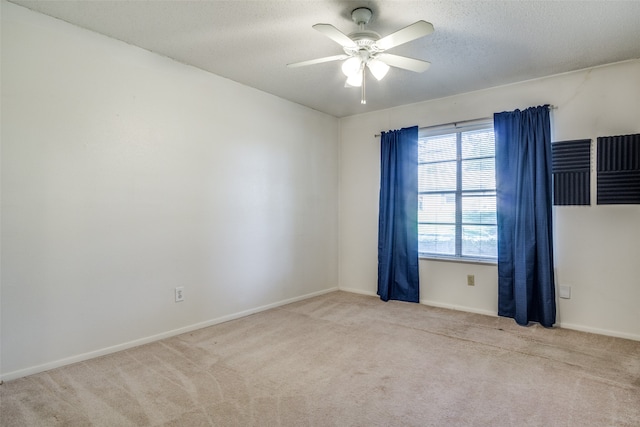 carpeted empty room featuring a textured ceiling and ceiling fan