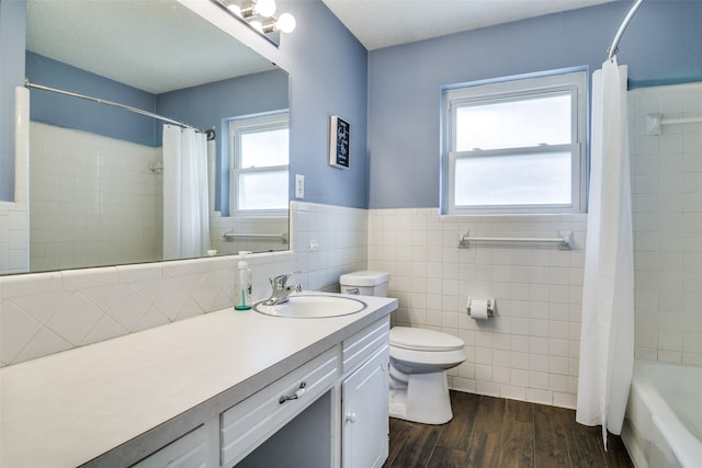 full bathroom with a wealth of natural light, vanity, wood-type flooring, and toilet