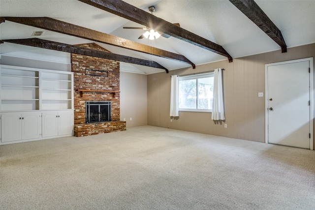 unfurnished living room featuring vaulted ceiling with beams, carpet floors, a brick fireplace, and ceiling fan