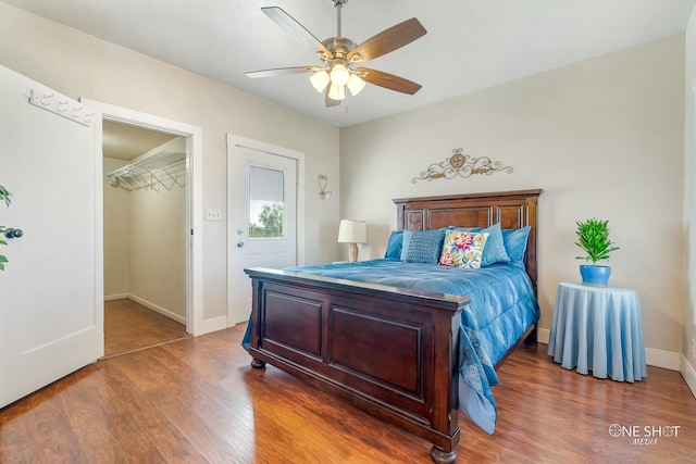 bedroom featuring ceiling fan, a closet, dark hardwood / wood-style flooring, and a spacious closet