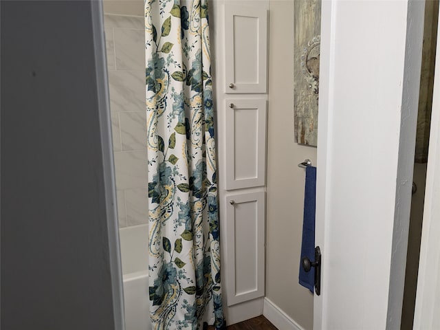 bathroom with shower / tub combo with curtain and wood-type flooring