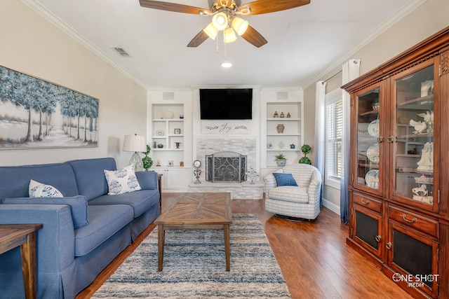 living room featuring ceiling fan, crown molding, dark hardwood / wood-style flooring, and built in features