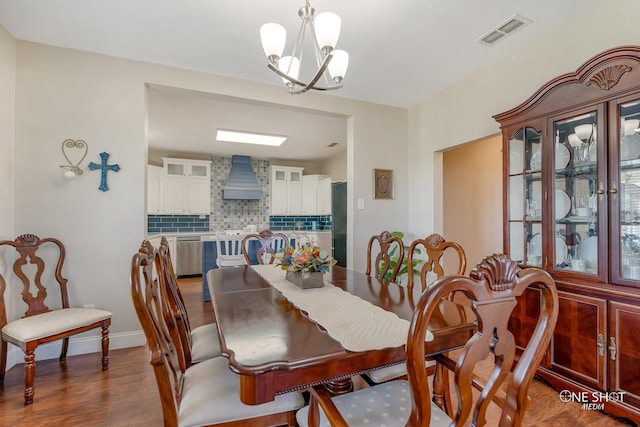 dining area with a notable chandelier and dark hardwood / wood-style floors