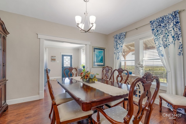 dining space featuring a notable chandelier, a wealth of natural light, and dark hardwood / wood-style flooring