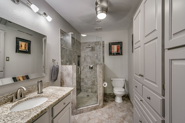 bathroom featuring vanity, tile patterned flooring, an enclosed shower, a textured ceiling, and toilet