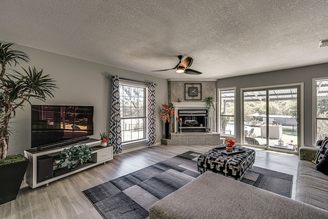 living room with wood-type flooring, a textured ceiling, and ceiling fan