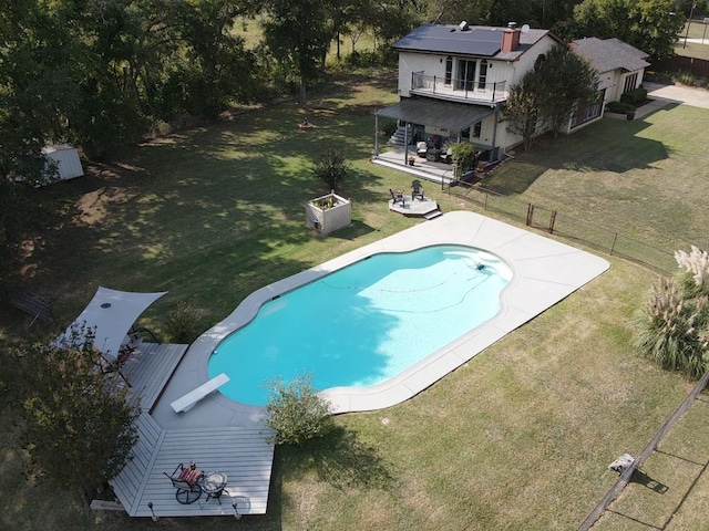 view of pool with a diving board, a yard, and a patio area