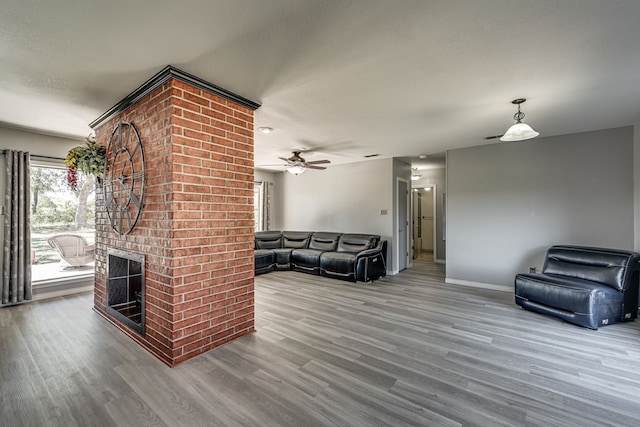 living room featuring a textured ceiling, a fireplace, ceiling fan, and hardwood / wood-style flooring