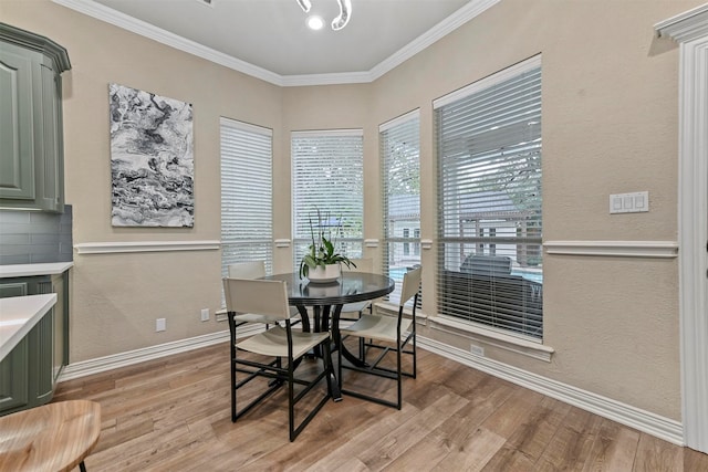 dining area with light hardwood / wood-style flooring and crown molding