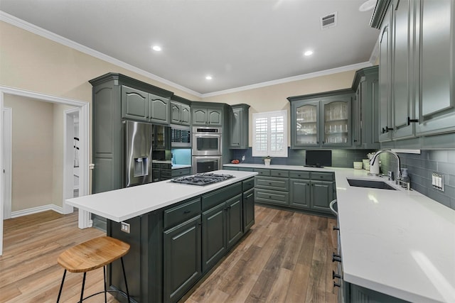 kitchen featuring sink, a kitchen island, stainless steel appliances, and hardwood / wood-style flooring