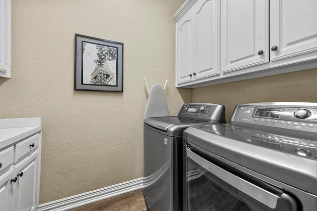 laundry room with dark hardwood / wood-style flooring, cabinets, and independent washer and dryer