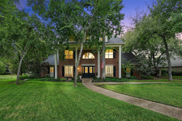 view of front of house featuring a yard and french doors