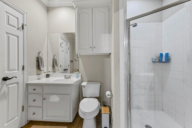 bathroom featuring ornamental molding, vanity, toilet, and a shower with shower door