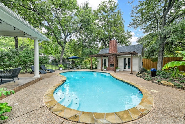 view of swimming pool featuring french doors, a patio, and a deck