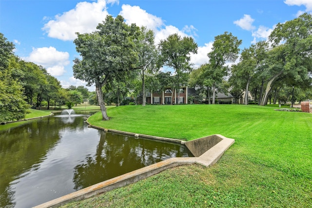 view of community featuring a lawn and a water view