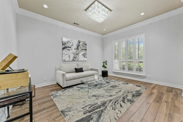 living room with ornamental molding, hardwood / wood-style flooring, and a notable chandelier