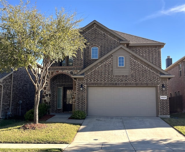 view of property with a garage and a front lawn