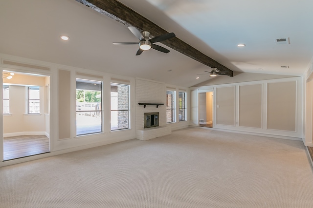 unfurnished living room with light carpet, vaulted ceiling with beams, a brick fireplace, and ceiling fan