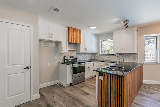 kitchen featuring white cabinets, electric stove, light wood-type flooring, and sink