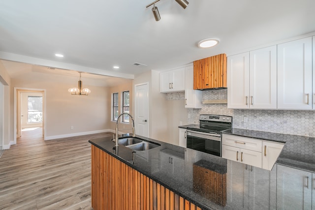 kitchen with stainless steel range with electric stovetop, plenty of natural light, sink, and white cabinetry