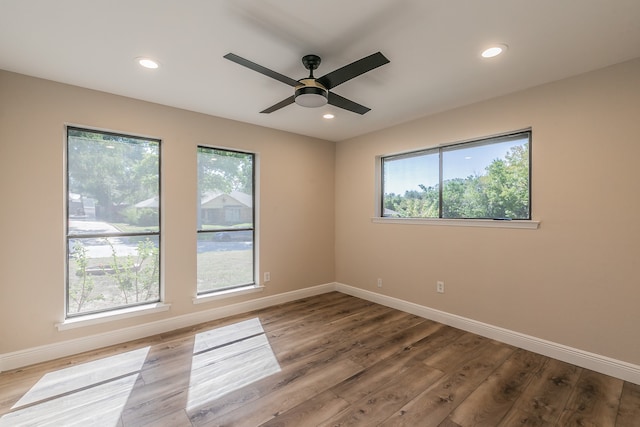 unfurnished room with wood-type flooring, ceiling fan, and a wealth of natural light