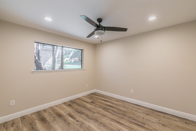 empty room with ceiling fan and light hardwood / wood-style floors