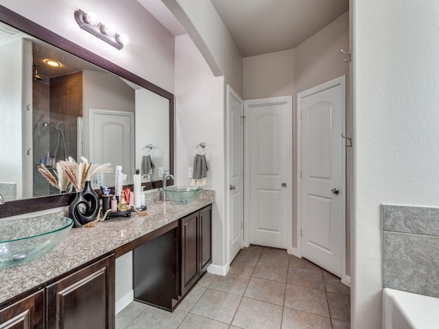 bathroom featuring vanity, a shower, and tile patterned flooring