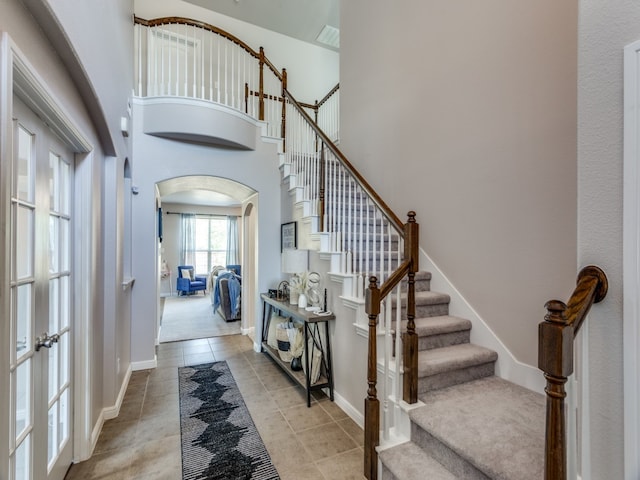 entryway featuring a towering ceiling and light tile patterned flooring