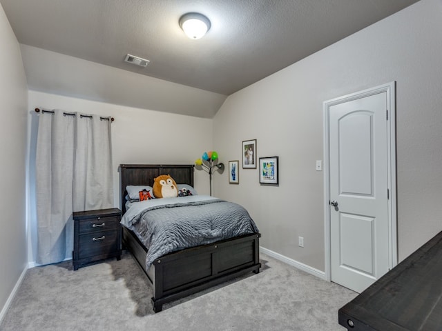 carpeted bedroom with a textured ceiling and lofted ceiling