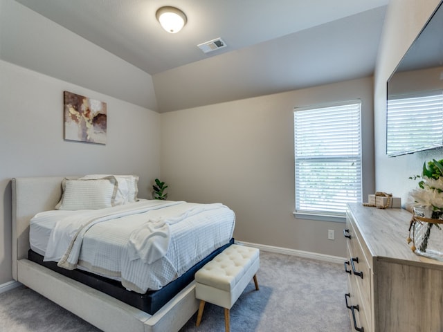 bedroom with vaulted ceiling and light carpet