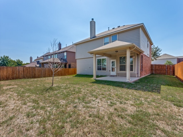 rear view of property featuring a lawn and a patio area