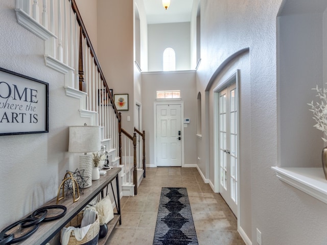 tiled foyer entrance featuring a high ceiling