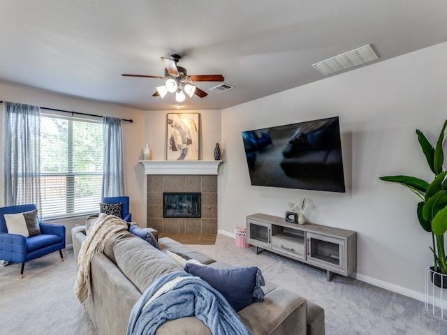 carpeted living room with a fireplace and ceiling fan