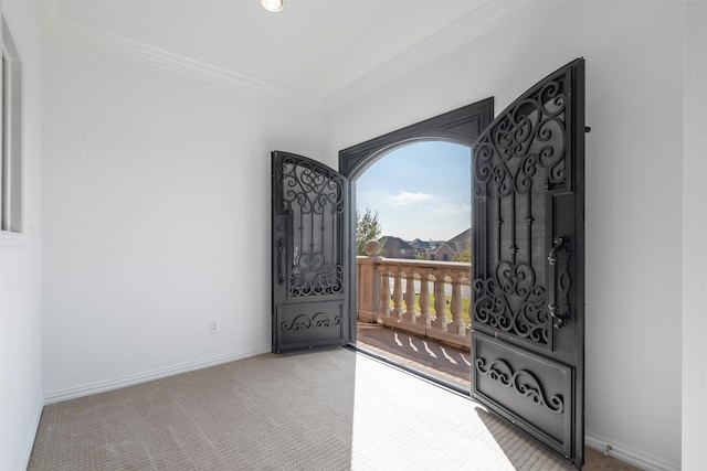 foyer entrance with light carpet and crown molding