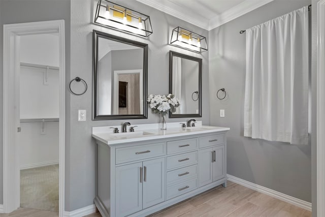 bathroom with vanity, hardwood / wood-style flooring, and crown molding