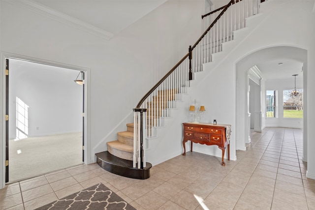 staircase featuring carpet flooring, a towering ceiling, and crown molding