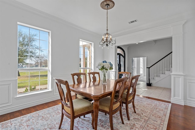 dining space featuring light wood-type flooring, plenty of natural light, and crown molding