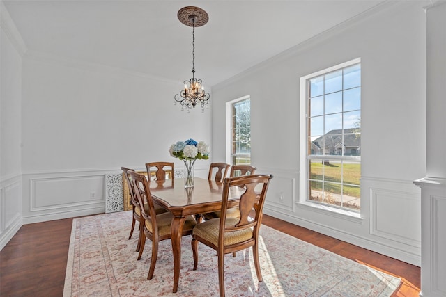 dining space featuring dark hardwood / wood-style floors, ornamental molding, and a chandelier