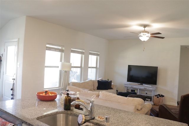 living room with lofted ceiling, sink, and ceiling fan