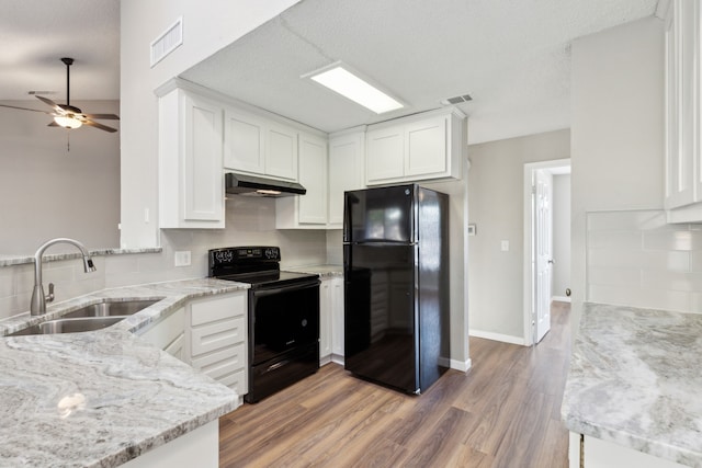 kitchen with sink, black appliances, and white cabinets