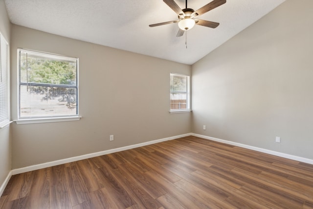 empty room with dark hardwood / wood-style floors, a textured ceiling, vaulted ceiling, and ceiling fan