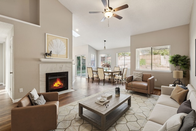 living room featuring ceiling fan, high vaulted ceiling, and light hardwood / wood-style flooring